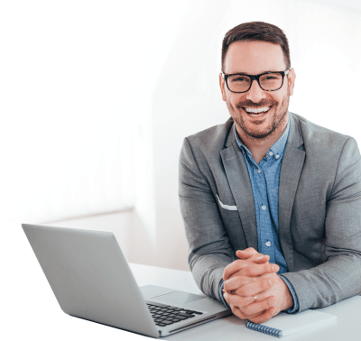 Photo: Happy business executive at laptop ready for AI Leadership training.